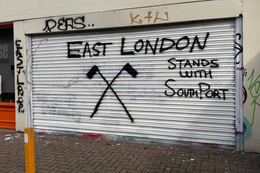 The front of Release's office spray painted with the slogan "East London stands with Southport."