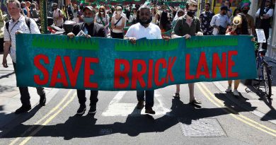 Campaigners bearing a red and green banner with Save Brick Lane at the Battle for Brick Lane campaign in 2022.