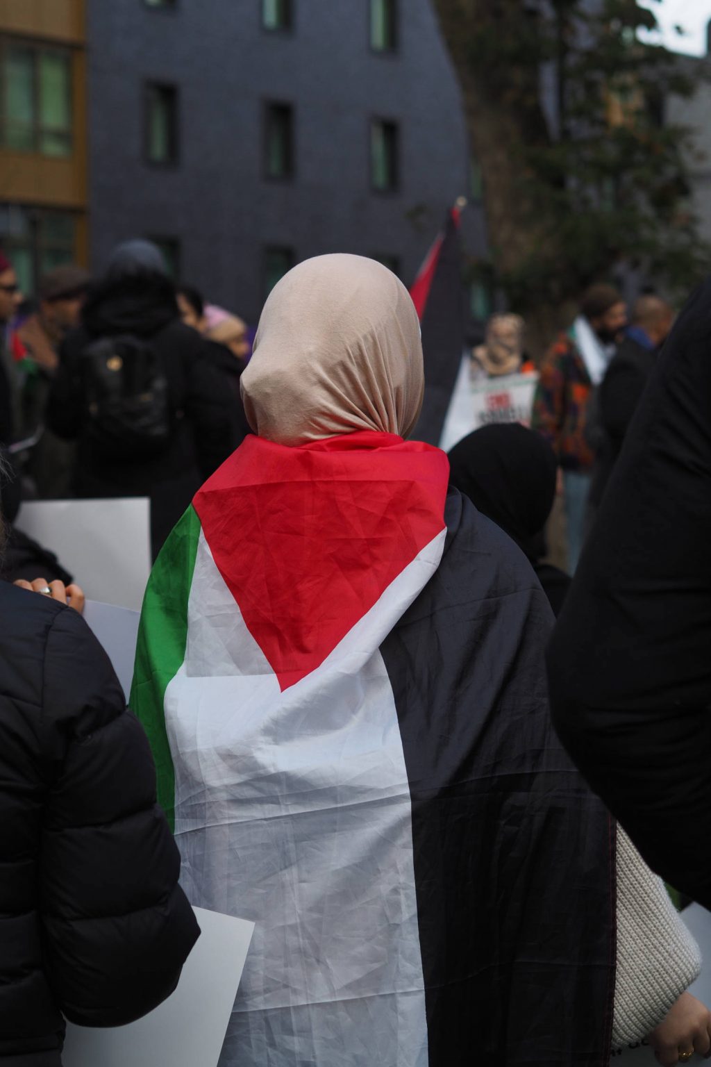 A protester at Altab Ali Park wearing a Palestinian flag. 