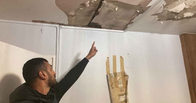 Muhammad Haque pointing to the damage in his parents home Credit: Ruby Gregory