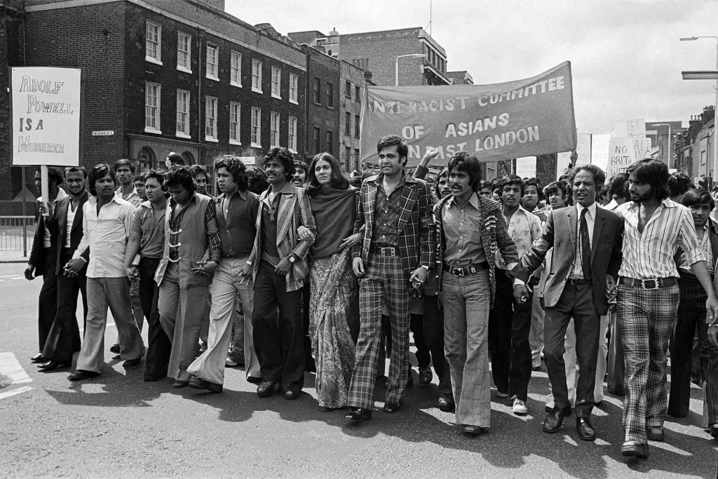 The Anti-Racist Committtee of Asians in East London marching down Whitechapel Road in 1976, bearing the banner 'Adolf Powell is a Murderer.