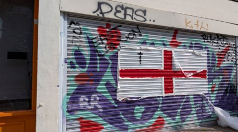 The front of Release's office spray painted with a white and red St. George's Cross.